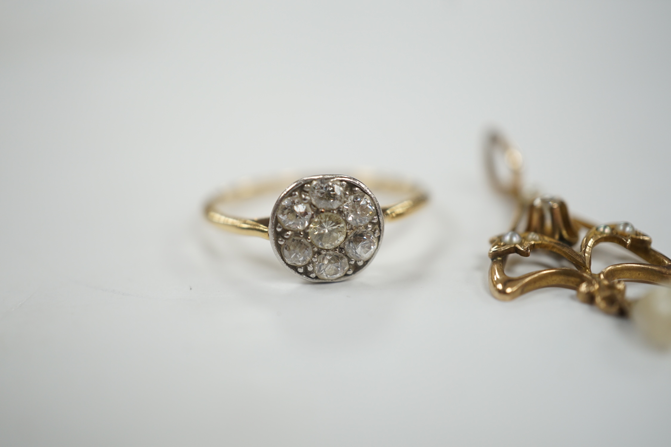 A yellow metal and seven stone diamond set circular cluster ring, size M/N, together with a small Edwardian yellow metal, diamond and seed pearl set drop pendant, gross weight 3 grams.